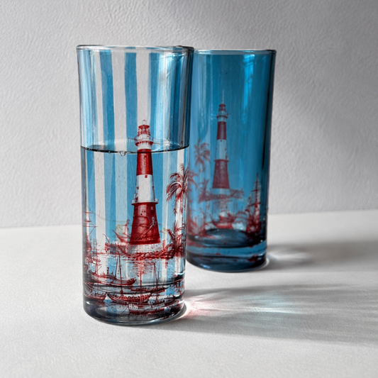 The Bombay Tide Glasses — powder-blue striped water glasses with burgundy lighthouse and palm illustration