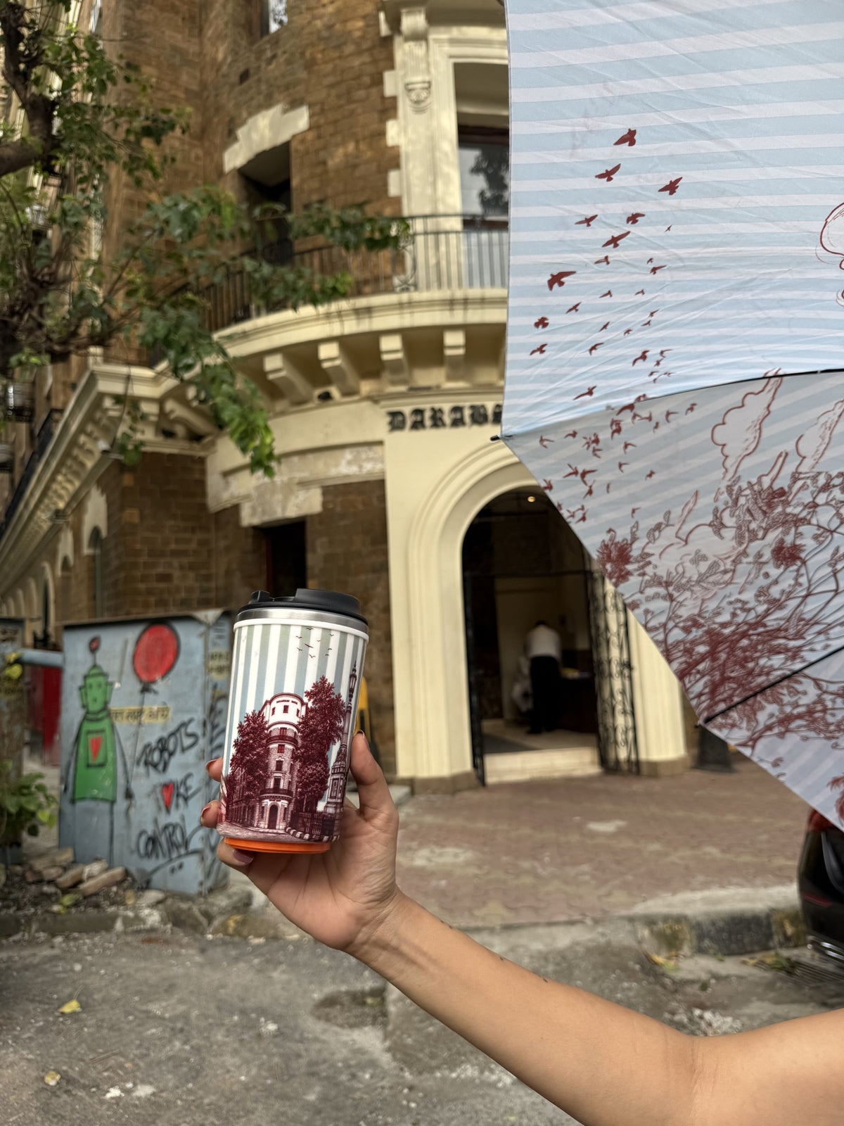 The Lamp & Palm Mug in front of the heritage facade its toile drawing is taken from